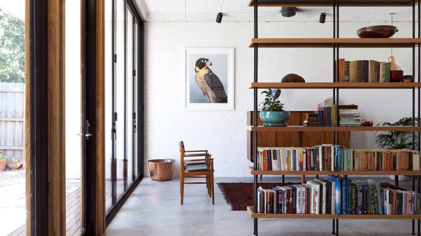 A bookshelf acting as a room divider in an living room