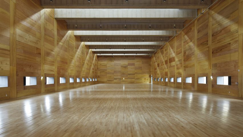 Steel-clad clerestory windows protrude from concrete badminton hall by JHW IROJE Architects