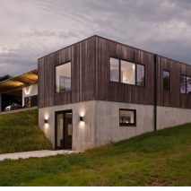 Haus wraps low-lying Indiana residence in thermally treated ash