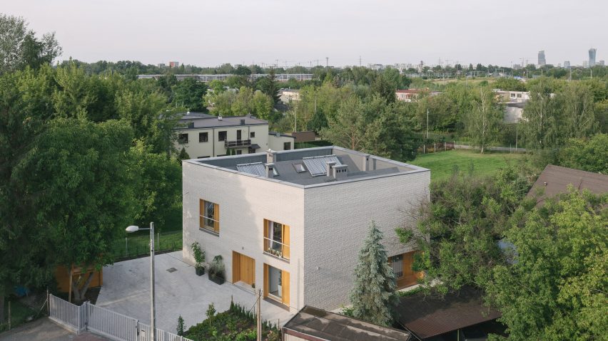 Oak-lined windows contrast pale brick facades at MFRMGR’s house in Warsaw