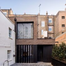 Pivoting louvres conceal windows set into brick facade of mews house by Belsize Architects
