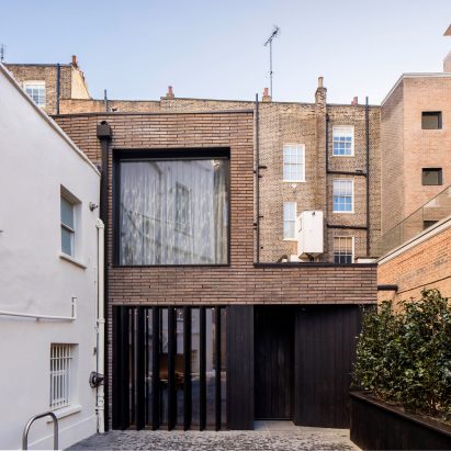 Pivoting louvres conceal windows set into brick facade of mews house by Belsize Architects