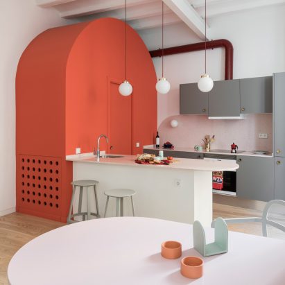 Deep-blue cabinetry and coral-pink arches redefine Barcelona apartment