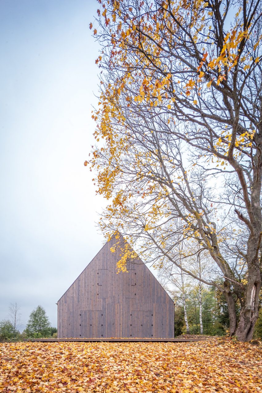 Aketuri Architektai conceals windows and doors behind large timber shutters at Lithuanian lakeside retreat