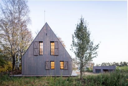 Aketuri Architektai conceals windows and doors behind large timber shutters at Lithuanian lakeside retreat