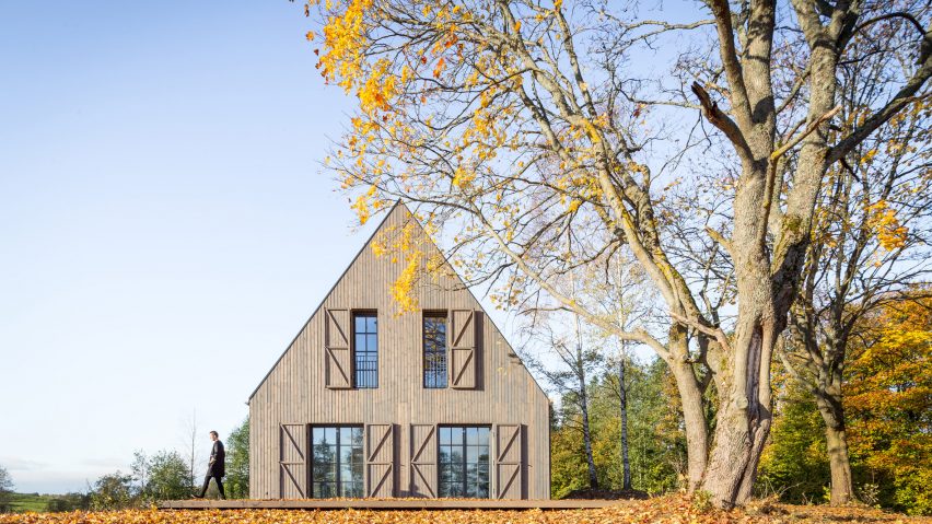 Aketuri Architektai conceals windows and doors behind large timber shutters at Lithuanian lakeside retreat