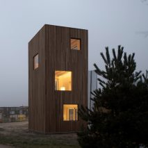 Sliding doors and built-in furniture save space inside skinny house by Ana Rocha Architecture