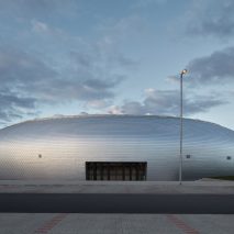 Domed sports hall by Sporadical is covered in scale-like aluminium shingles