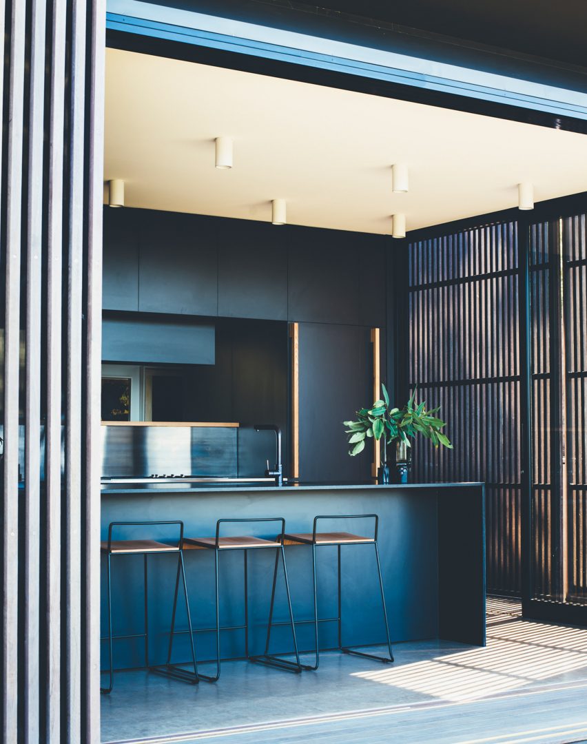 Sliding eucalyptus-wood screens wrap exterior of house on Australia's Sunshine Coast