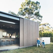 Sliding eucalyptus-wood screens wrap exterior of house on Australia's Sunshine Coast