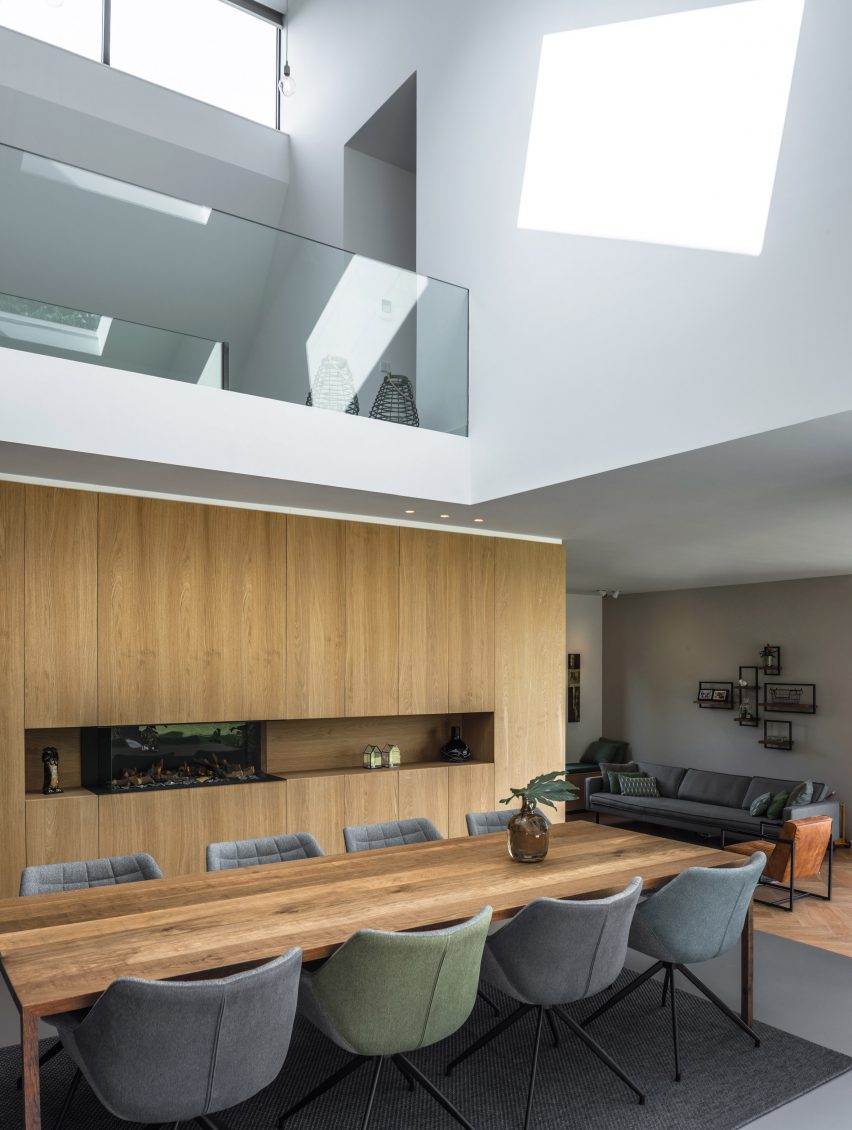 Villa IJsselzig by EVA Architecten is a riverside home featuring red-brick walls and a patinated copper roof