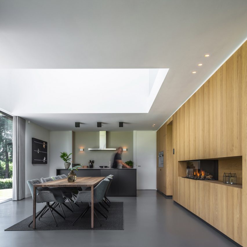 Villa IJsselzig by EVA Architecten is a riverside home featuring red-brick walls and a patinated copper roof