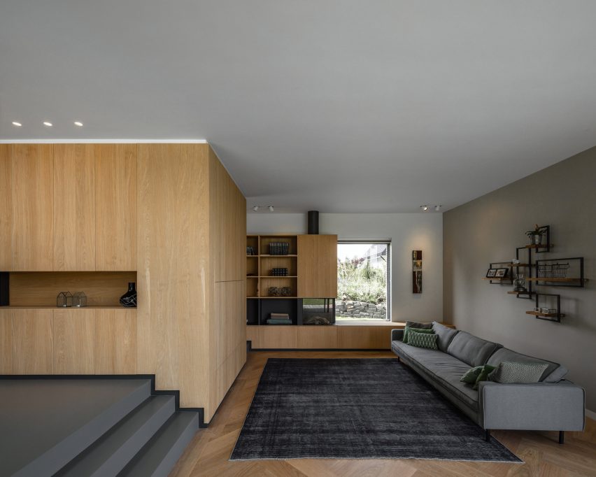 Villa IJsselzig by EVA Architecten is a riverside home featuring red-brick walls and a patinated copper roof