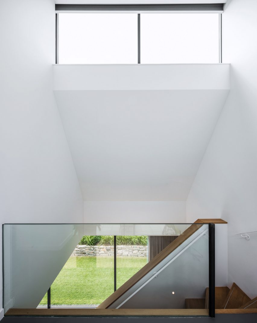 Villa IJsselzig by EVA Architecten is a riverside home featuring red-brick walls and a patinated copper roof