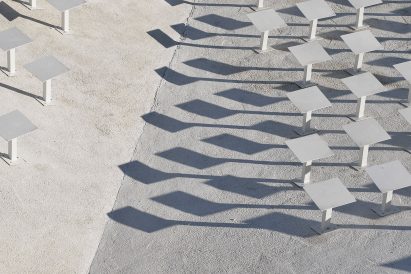 Sloping concrete volumes enclose social hub and chapel in a Slovenian village