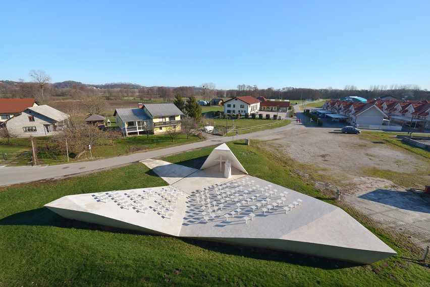 Sloping concrete volumes enclose social hub and chapel in a Slovenian village