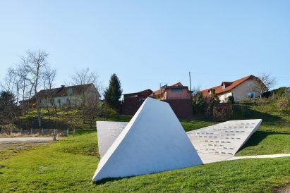 Sloping concrete volumes enclose social hub and chapel in a Slovenian village