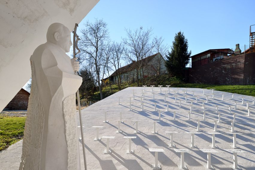 Sloping concrete volumes enclose social hub and chapel in a Slovenian village