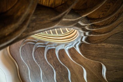 Atmos Studio's spiralling timber staircase features "leaf-like" stairs that emerge from a structural stem