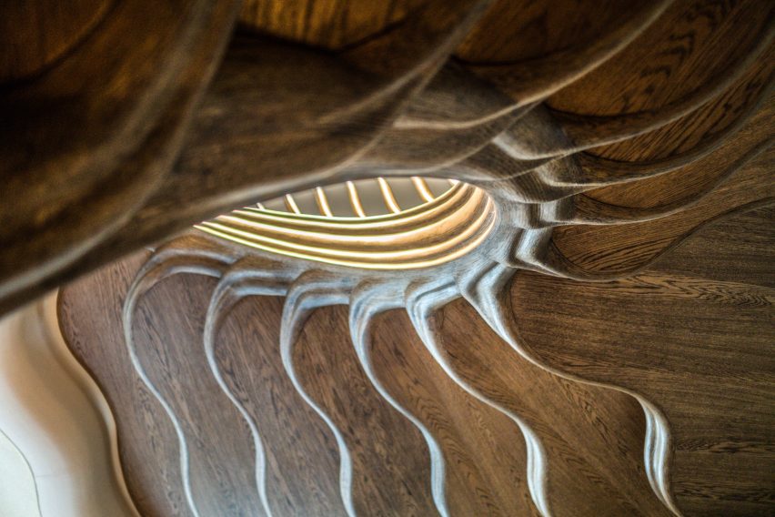 Atmos Studio's spiralling timber staircase features "leaf-like" stairs that emerge from a structural stem