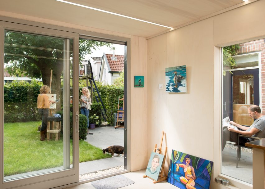 Timber-clad painting studio by Open Kaart wraps around and old brick shed