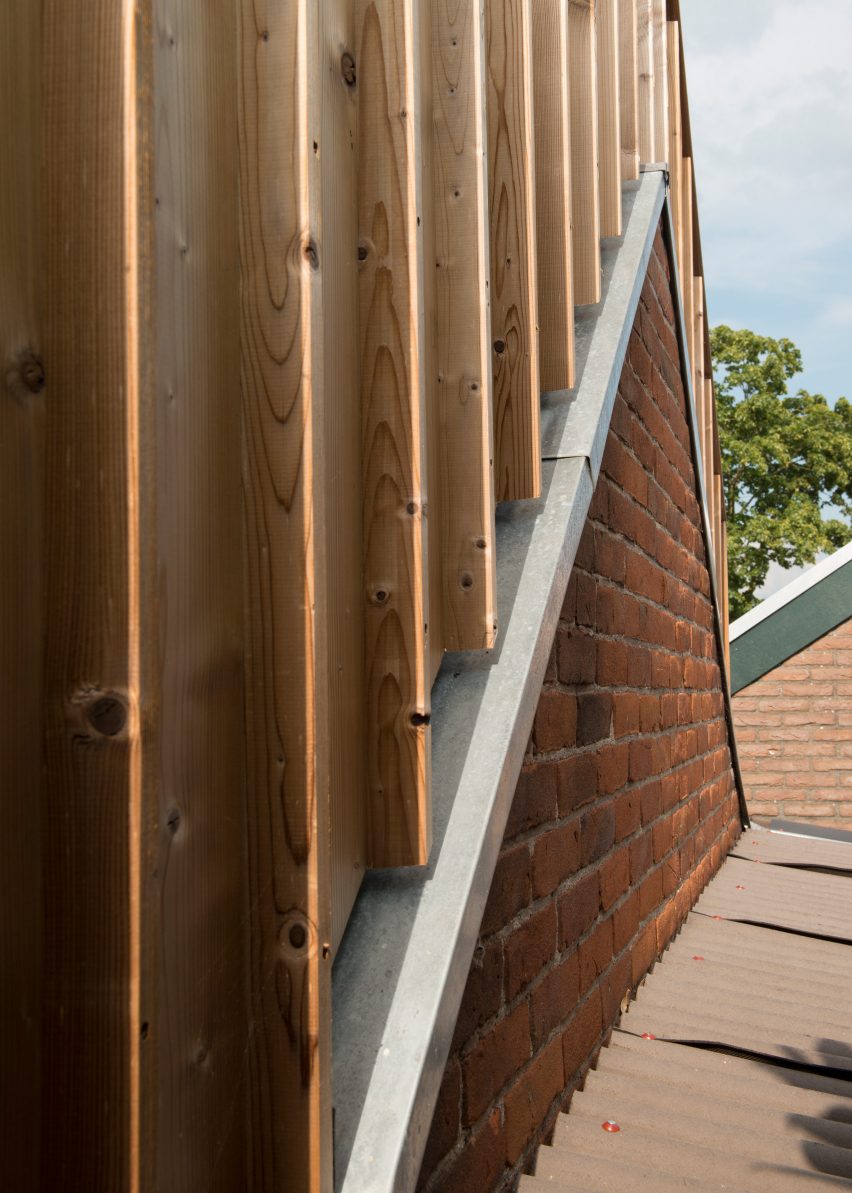 Timber-clad painting studio by Open Kaart wraps around and old brick shed