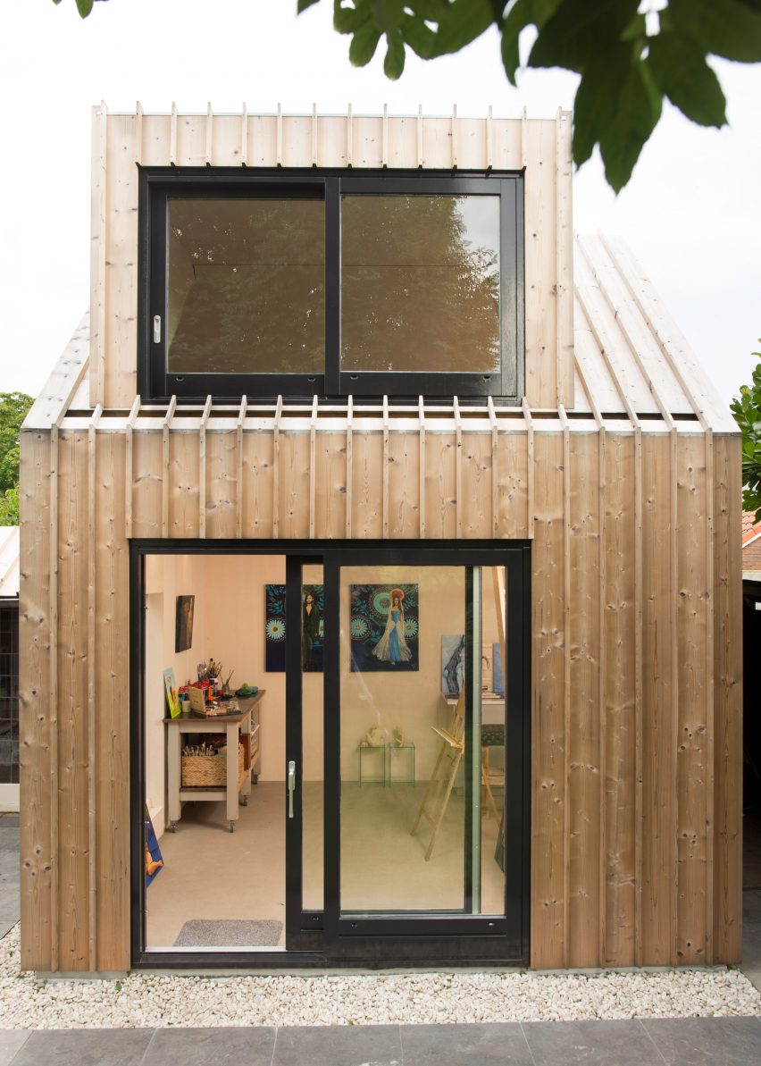 Timber-clad painting studio by Open Kaart wraps around and old brick shed