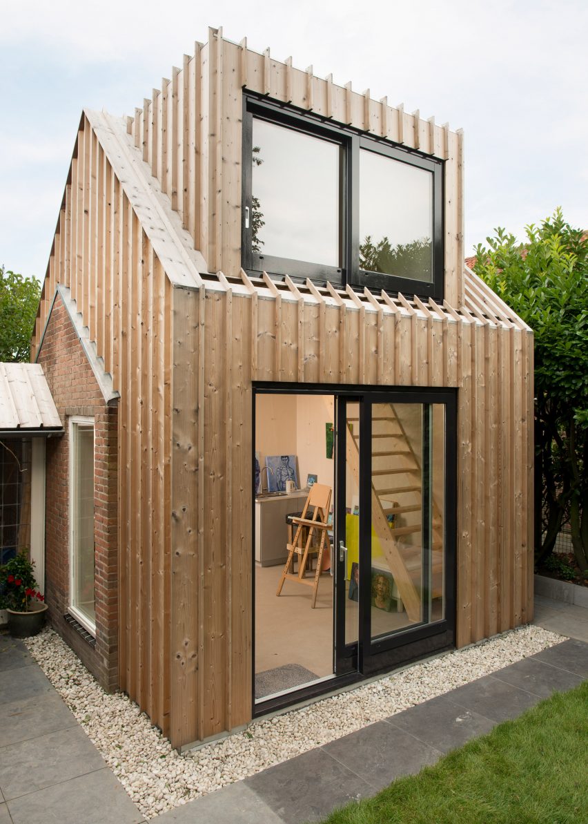 Timber-clad painting studio by Open Kaart wraps around and old brick shed