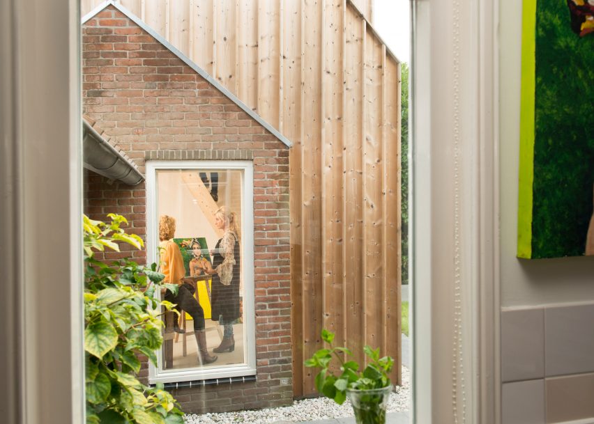 Timber-clad painting studio by Open Kaart wraps around and old brick shed