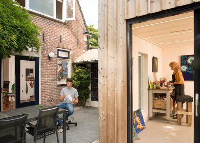 Timber-clad painting studio by Open Kaart wraps around and old brick shed