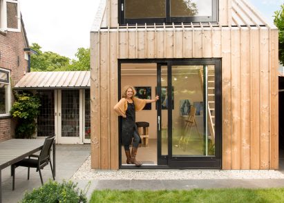 Timber-clad painting studio by Open Kaart wraps around and old brick shed