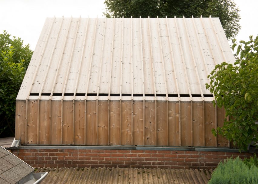 Timber-clad painting studio by Open Kaart wraps around and old brick shed