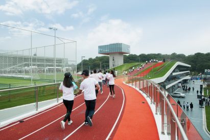 Hangzhou Cloud Town Exhibition Center by Approach Design has a green roof with a running track