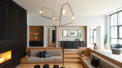 Living room area with sunken living room and statement abstract chandelier