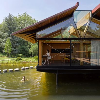 Stepping stones lead into house extension over an English lake by Hamish & Lyons