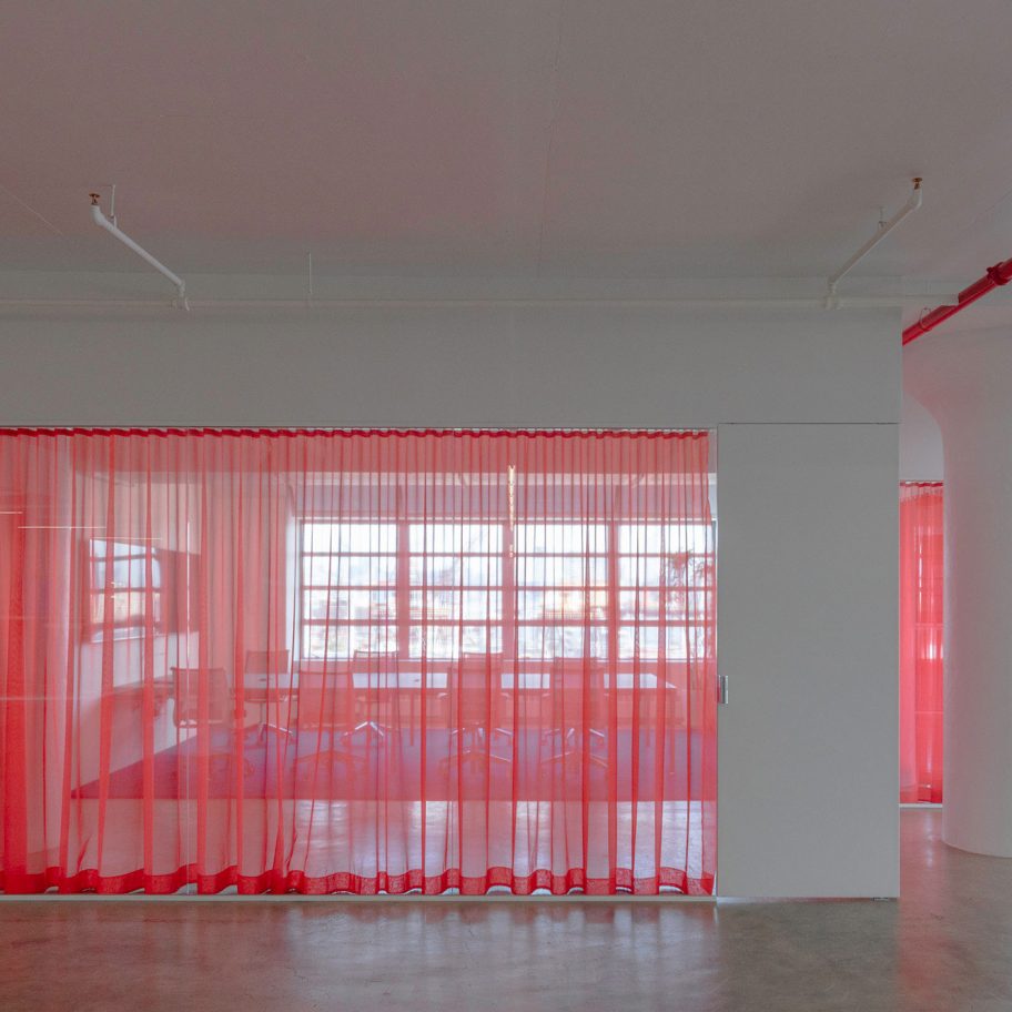 Red drapes partition stark white HUSH offices in Brooklyn