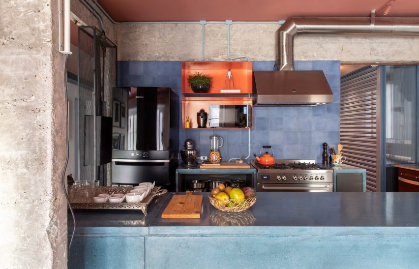 Kitchen at the RF Apartment by SuperLimão with blue kitchen island and steel extractor fan