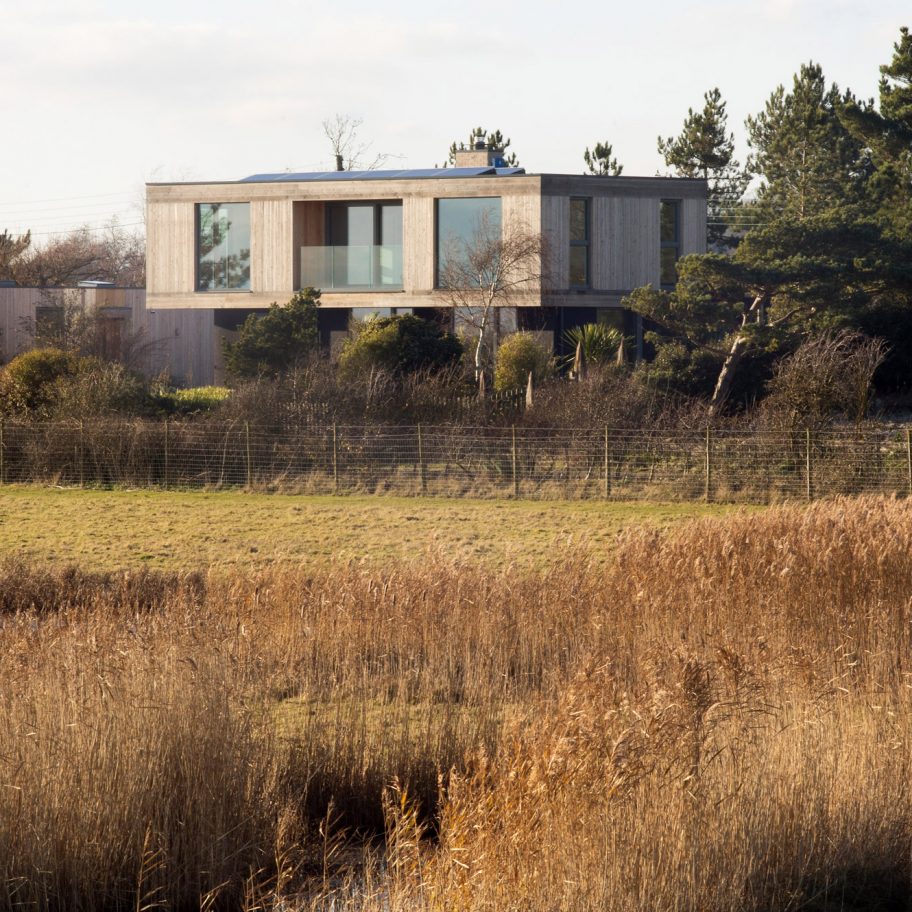 Larch-clad house by RX Architects cantilevers over landscape