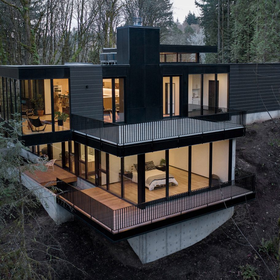 Black wood and glass volumes stagger down Oregon woodland to form Royal house