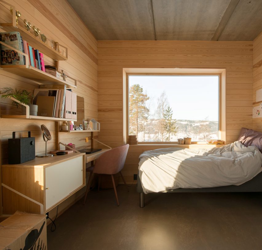 Bedroom with a desk in the red concrete house by Sanden+Hodnekvam