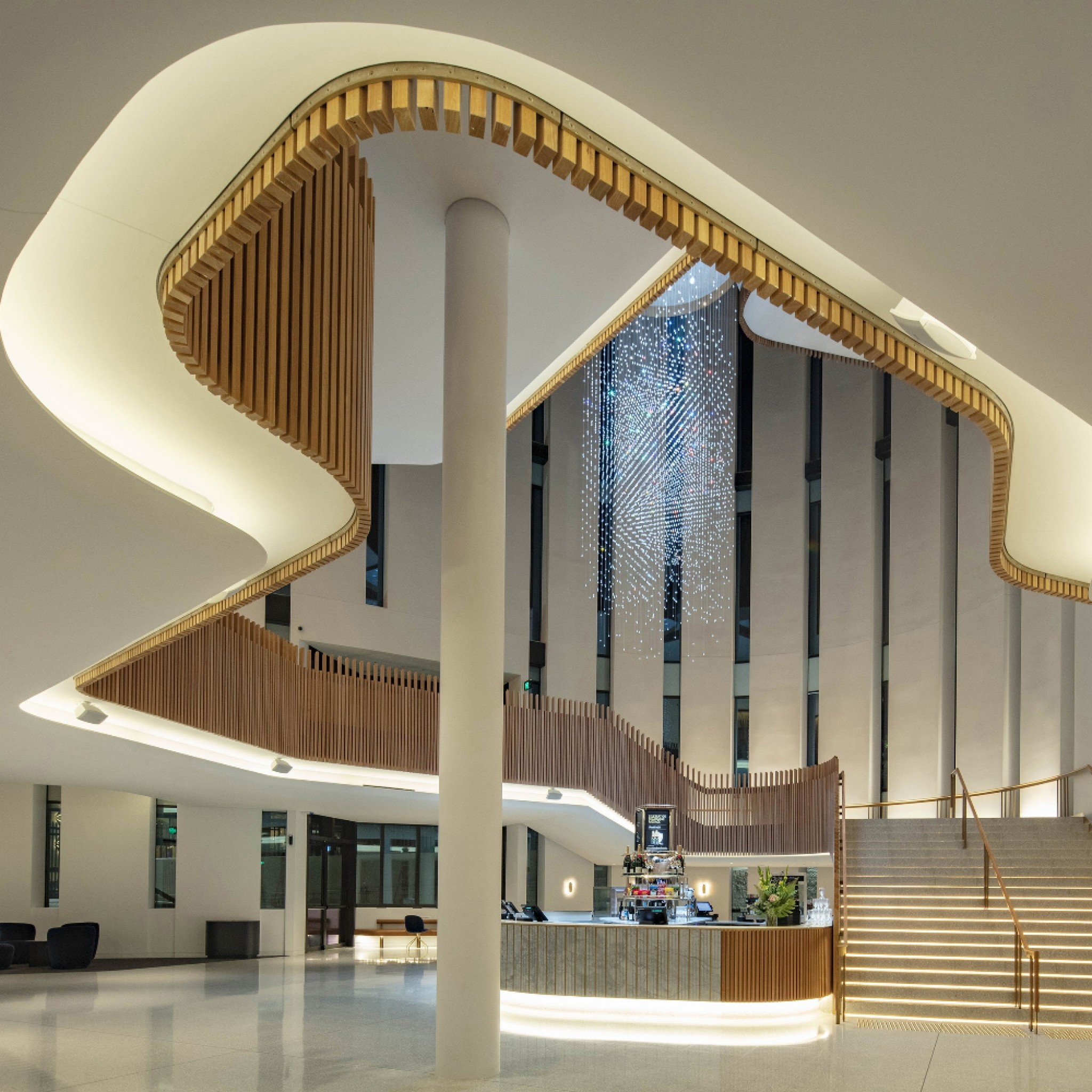 A rhythmic pattern of ribbon windows carved into deep reveals veil the mundane surrounds and minimise solar gain