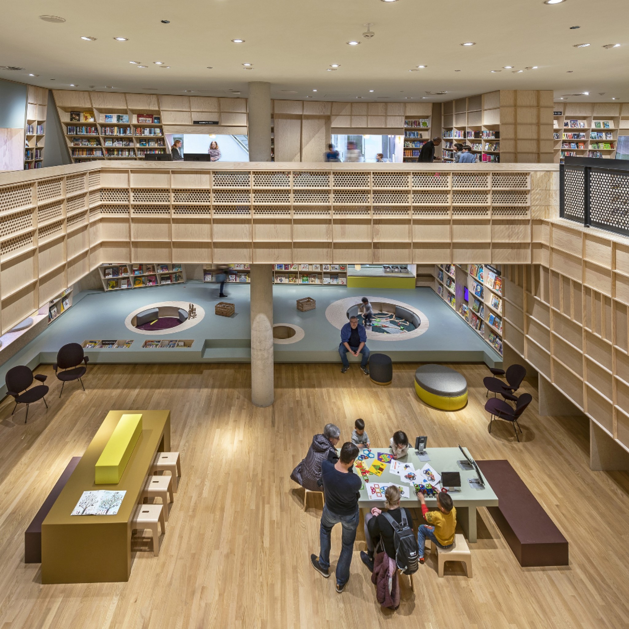 The interior emphasizes the architecture and offers space for more than just books: the children can curl up in the window niches, play in a chill net or experiment with techniques