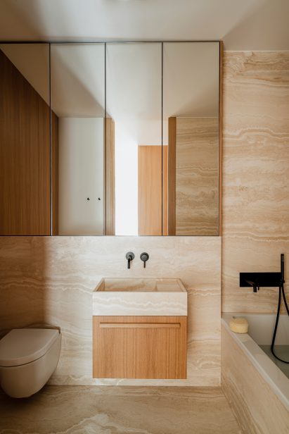 Travertine marble bathroom of Botaniczna Apartment by Agnieszka Owsiany Studio