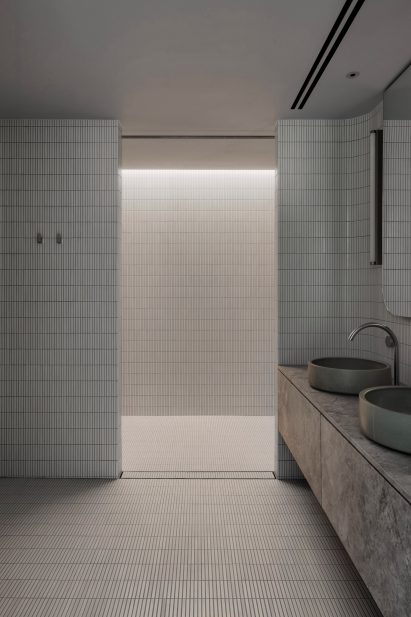 White-tiled bathroom inside The Melburnian Apartment by Edition Office