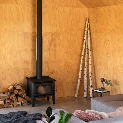 Plywood-lined living room with wood-burning stove