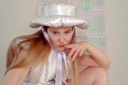 Santa Kupča wearing her Hesitant to RSVP duvet-style garment and hat