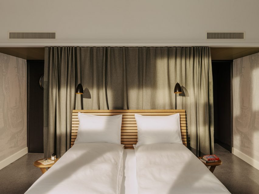 Bed with oak-slatted headboard in bedroom of Volkshaus Basel Hotel by Herzog & de Meuron
