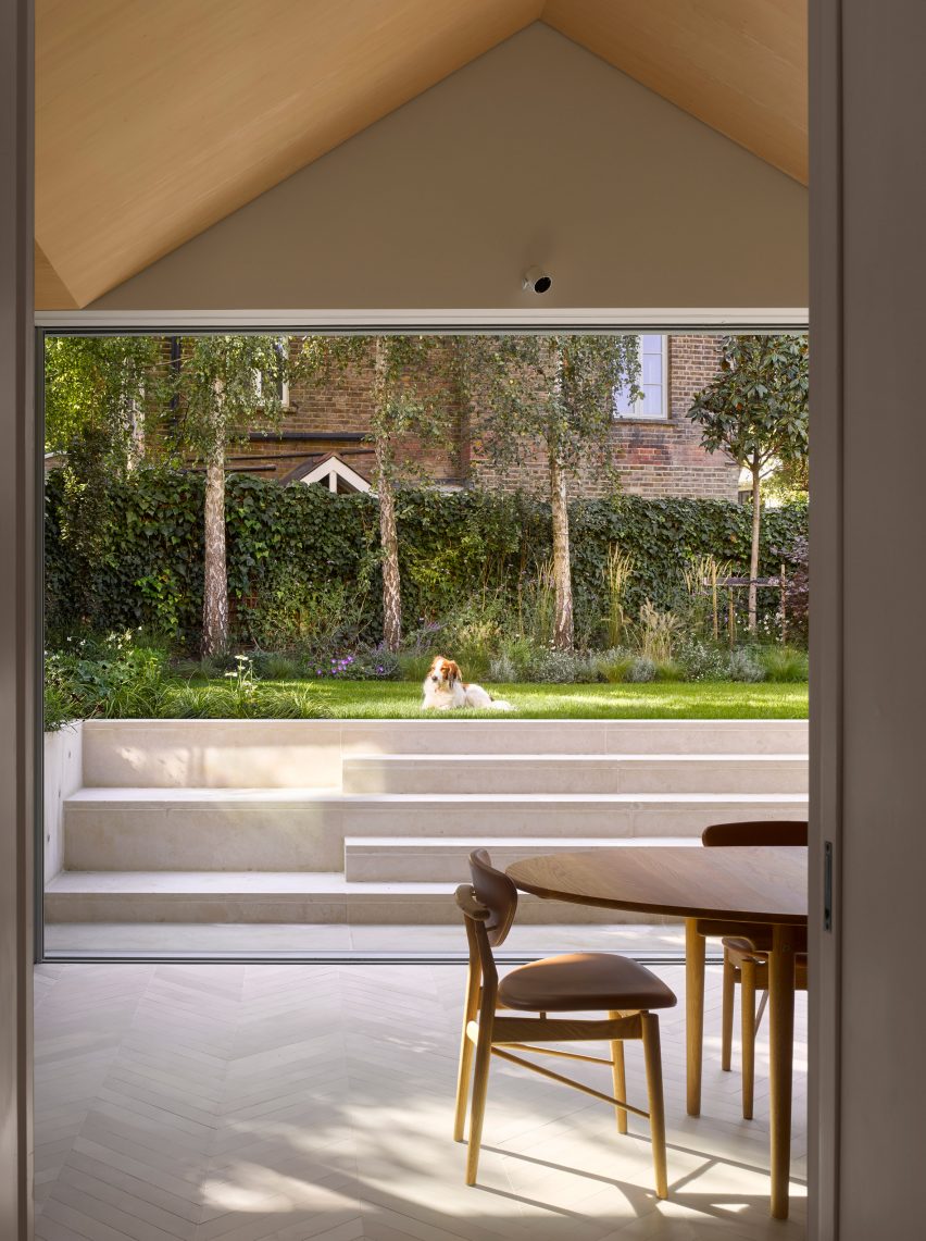 Glass doors open out to the garden in Hampstead House by Dominic McKenzie Architects