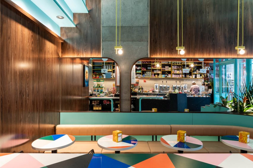The main black monolithic terrazzo bar reflected in the curved mirrors