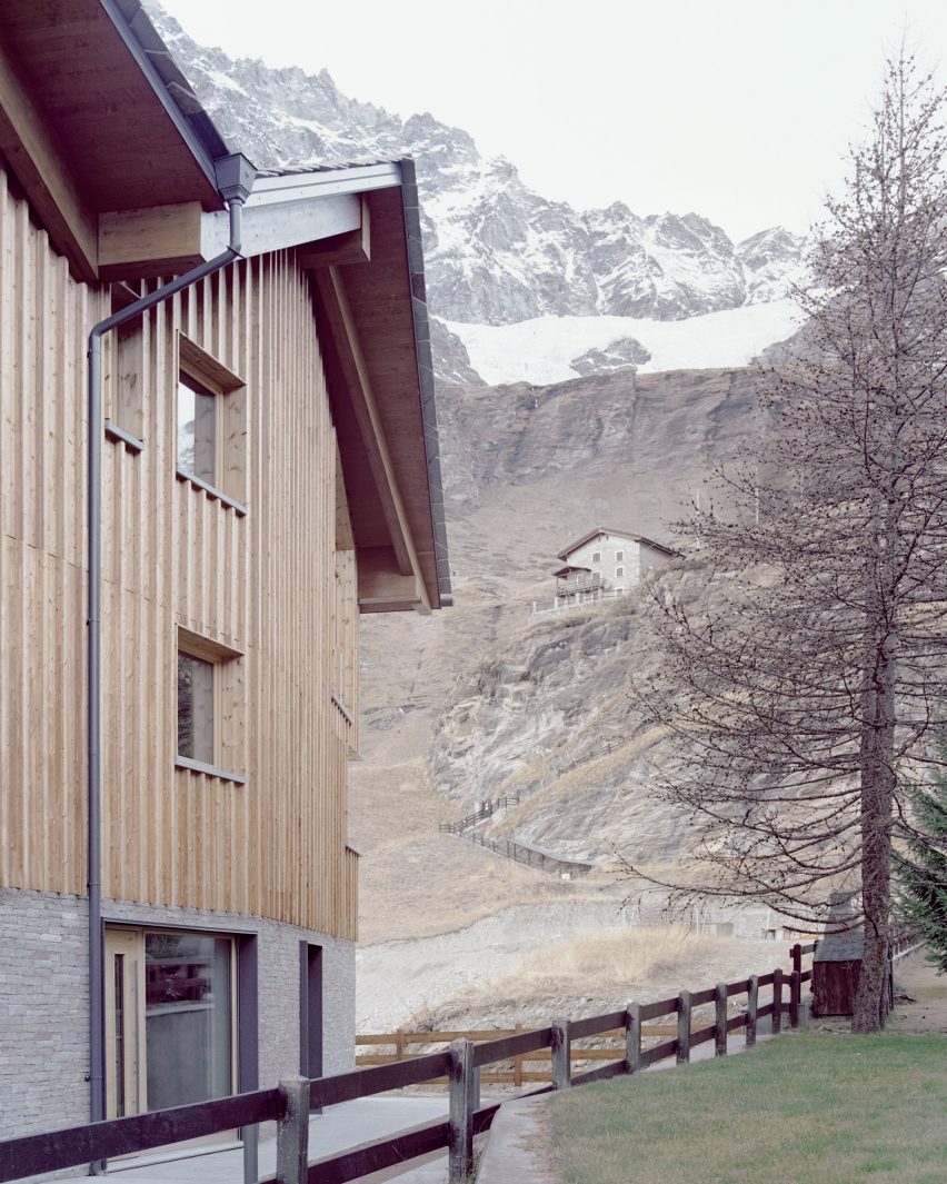 The exterior of a stone and wood-clad chalet by LCA Architetti